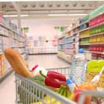 Supermarket trolley filled with vegetables in aisle