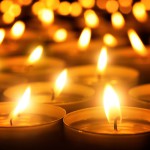 Many candle flames glowing in the dark, create a spiritual atmosphere